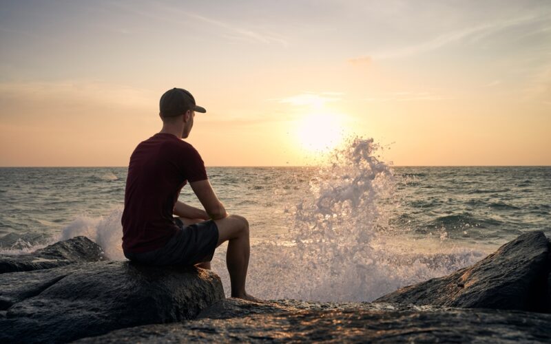 Man Sitting Next To Ocean And Contemplating What Does Weight Regain Look Like After Stopping Wegovy