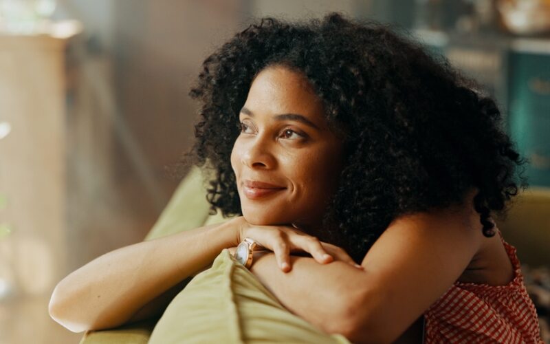 Woman who started taking Sermorelin on couch calming herself after feeeling anxiety or restlessness.