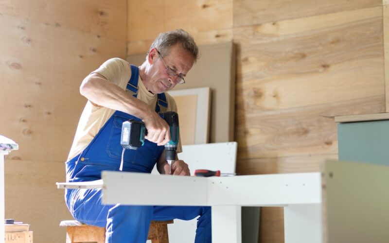 Older man working with power tools in a home workshop, representing strength, independence, and healthy aging supported by adequate vitamin B12 levels.