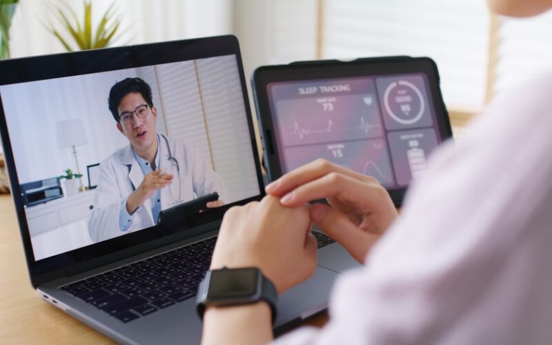 Person having a telehealth video consultation with a doctor on a laptop, representing mental health evaluation, anxiety and mood disorder testing, and accessing lab tests without long wait times.