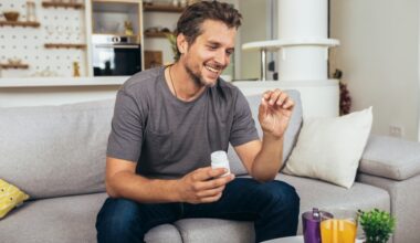 Man at home holding an erectile dysfunction pill and medication bottle, illustrating how ED pills like Viagra and Cialis work to support erections through improved blood flow.
