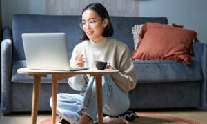 A woman sitting at home uses a laptop for an online healthcare consultation while researching medication options, representing telehealth and Ozempic alternatives.