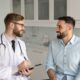 A doctor talking with a male patient during a first weight loss lab visit, discussing symptoms and lab testing.
