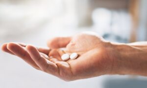 A person holding their pills. They are in the process of increasing their dose for their Wegovy pill