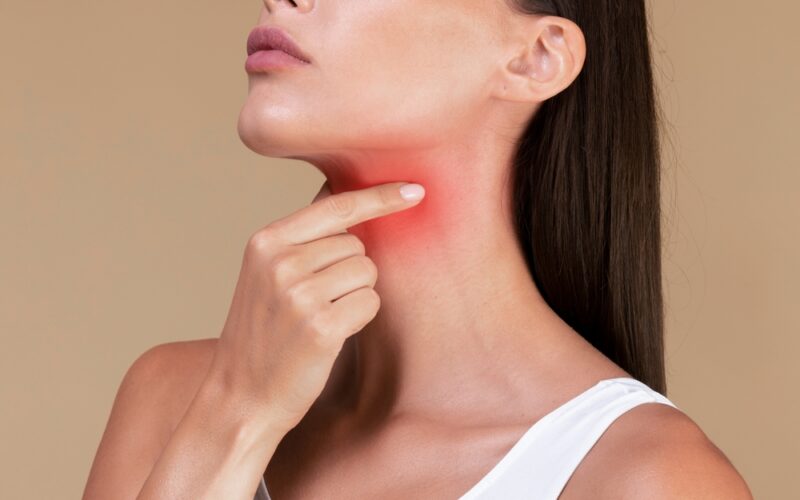 Woman feeling her neck. Worried about thyroid cancer