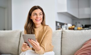 older woman using digital tablet at home. They are using zepbound to while in perimenopause/menopause