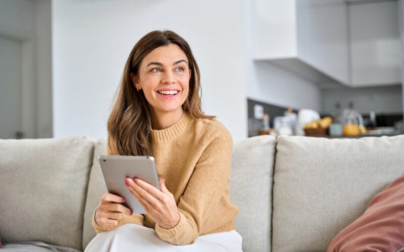 older woman using digital tablet at home. They are using zepbound to while in perimenopause/menopause