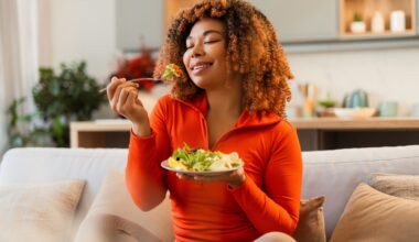 Young african american woman eating green salad, having a healthy meal after she stopped taking wegovy
