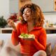 Young african american woman eating green salad, having a healthy meal after she stopped taking wegovy