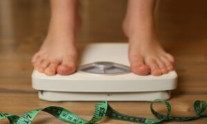 A person weighing themselves after what is saxenda and trying it for weight loss.