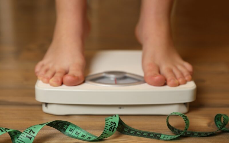 A person weighing themselves after what is saxenda and trying it for weight loss.